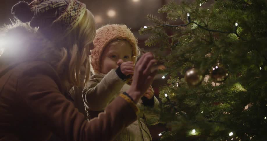 Woman and young child decorating a christmas tree