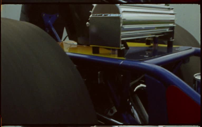 Wide tires of a racing car spinning inside the workshop