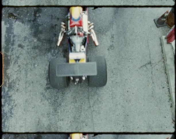 Film footage of a person walking as a race car drives past