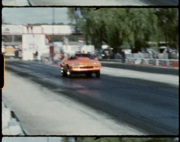 Two cars leave the starting line on a race track