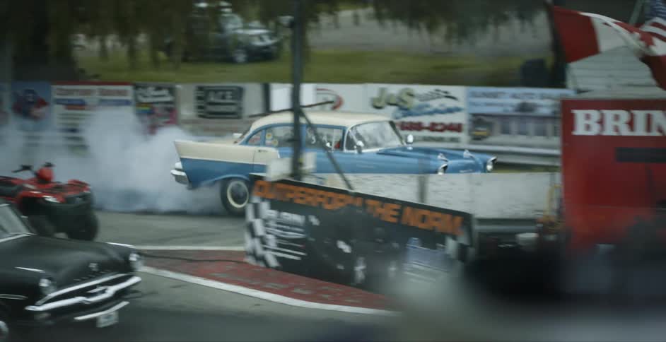 Two vintage race cars line up on the starting line of a race track