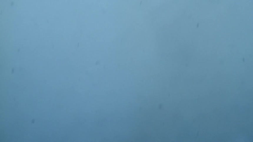Chunks of snow falling to the ground in a fog