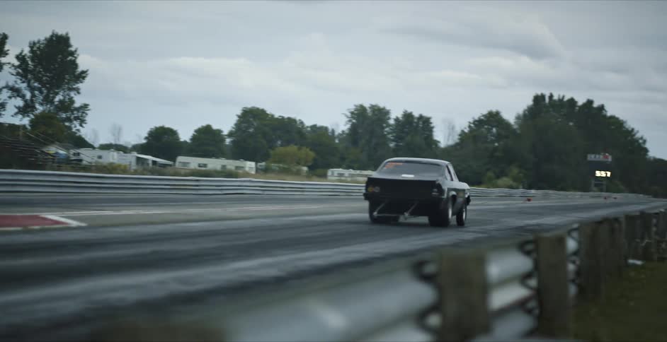 Two sports car start as light signals go and race down track