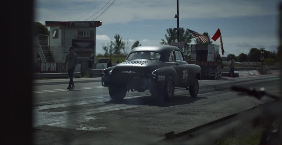 People stand on a track as a race car takes off