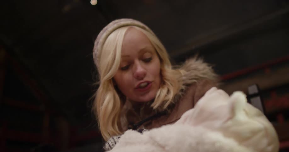 A smiling woman sings to the baby she holds