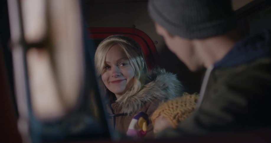 A man woman and baby sit in a car