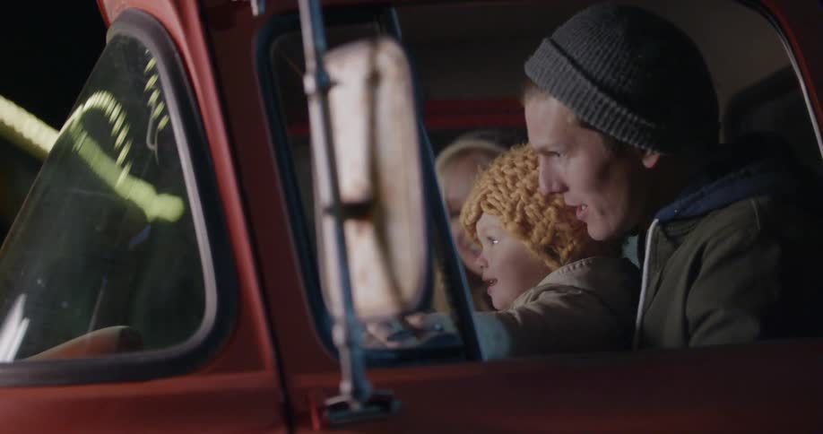 A man sits with his son on his lap inside a truck