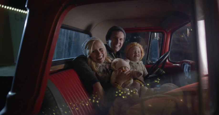 A family in an old farm truck on a winter night