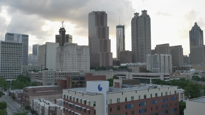 Several tall skyscrapers standing in front of cloudy skies
