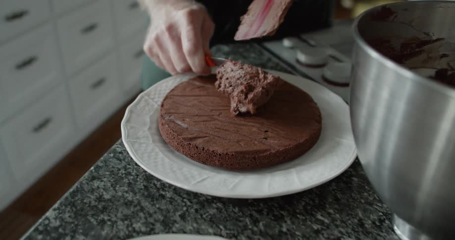 A person putting frosting onto a cake