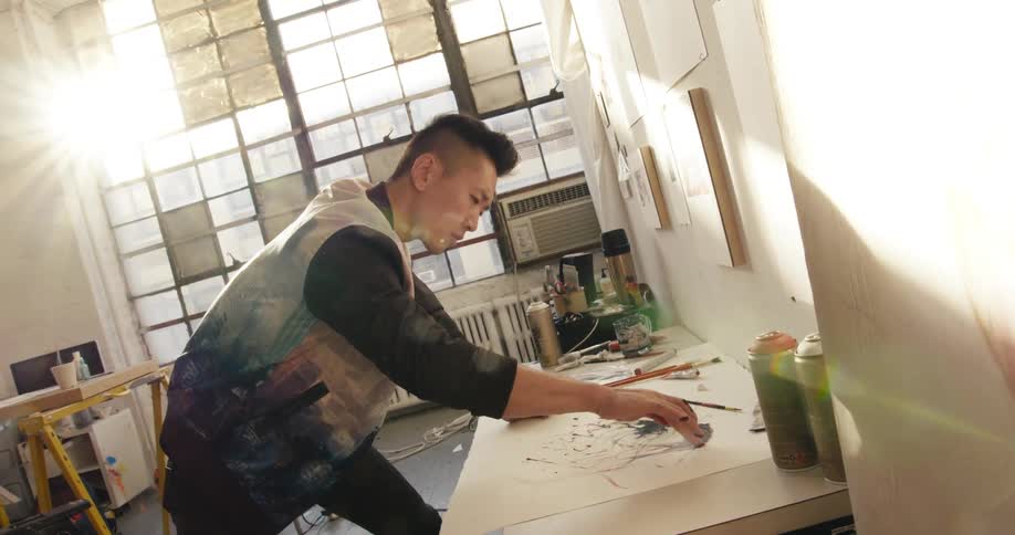A man painting with his hands in a studio