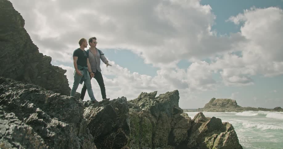 Two people that are standing at the ocean