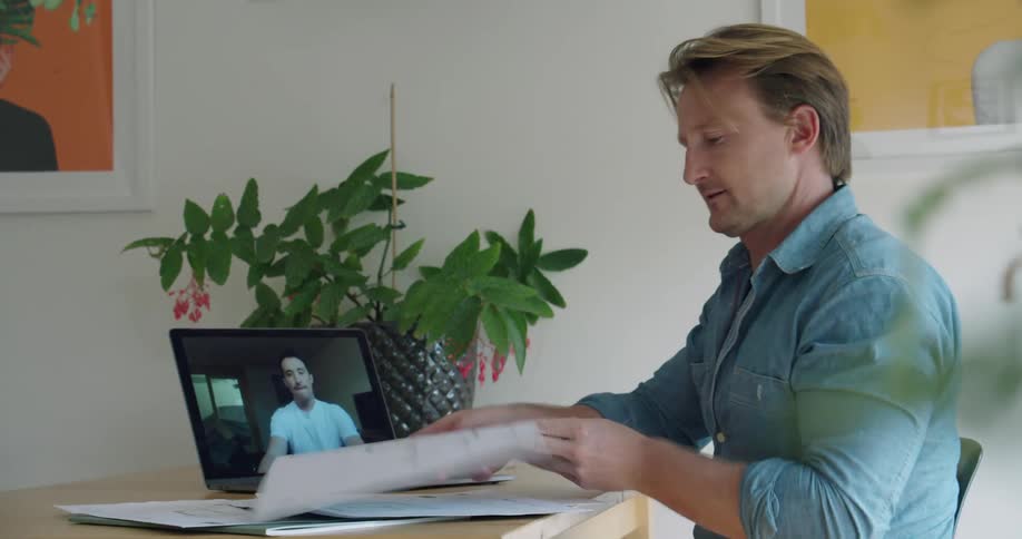 Two men talking to each other on a laptop