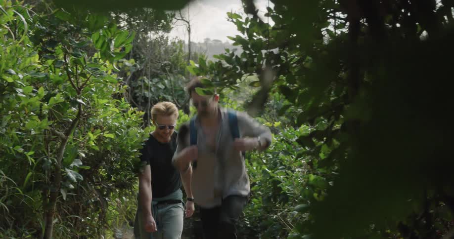 Two men hike up slight slope through woods