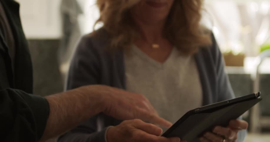 A man and woman looking at a tablet