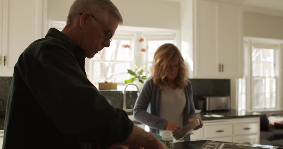 A man and woman cooking food in a kitchen