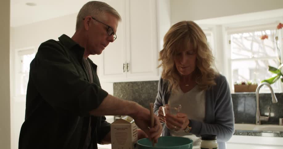 A man and woman cooking in a kitchen together