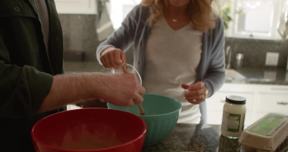 A man and woman baking at home together
