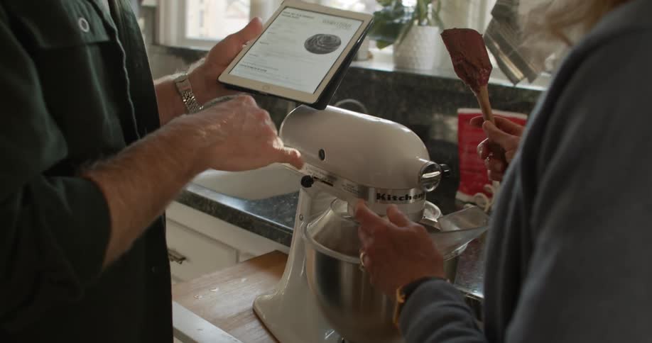 A man and woman looking at a tablet