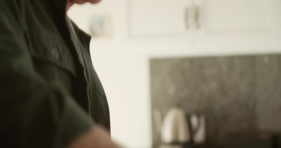 A couple stir ingredients in bowls as they cook together in their kitchen