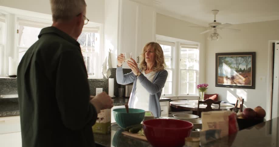 A woman brings a measuring cup into the kitchen to show her husband