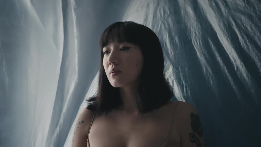 A woman stands in a room that is completely draped in sheer fabric