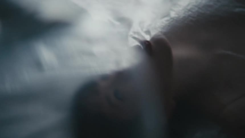 A thin filmy sheet covers and clings to a womans mouth and face