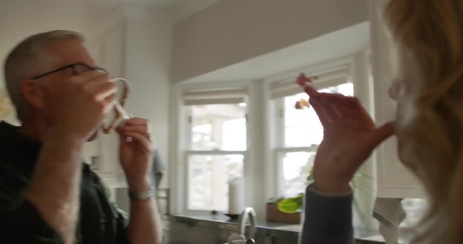 Couple licks mixture from fingers and beater of standalone mixer