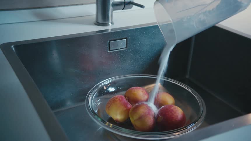 Sugar being poured onto a bowl of apples