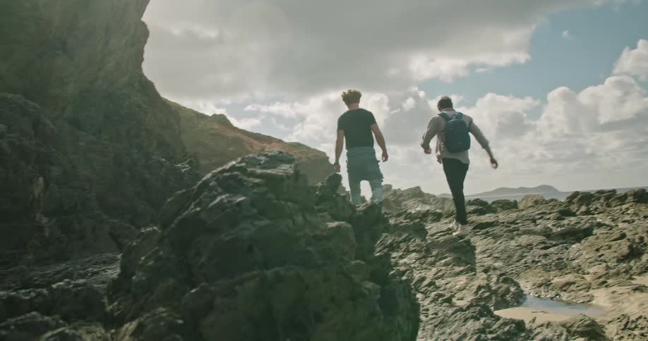 Two men laugh and chat as they hike in a canyon