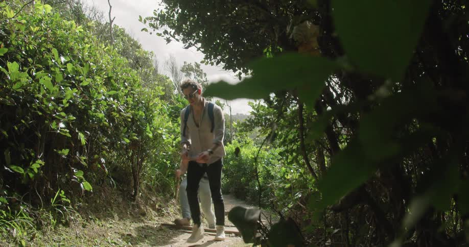 Two people that are hiking outdoors on a trail