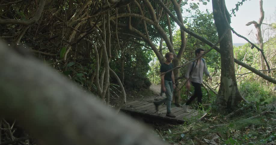 Two men that are walking on a trail in the forest