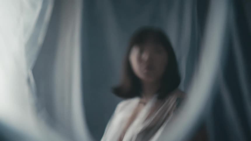 Clear glassshows woman draped in filmy material