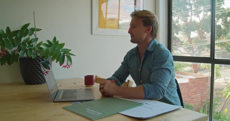 A man talking to someone on a laptop