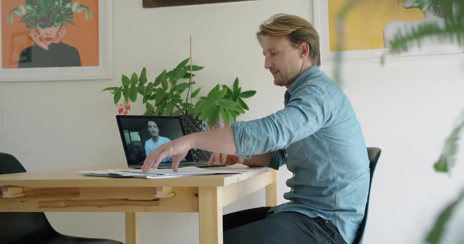 Men discuss work via laptop video call
