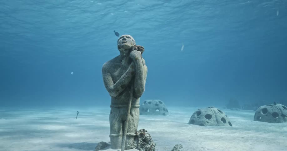 A view of a statue that is underwater in the ocean