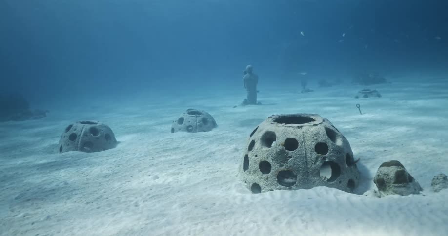 Sculptures submerged underwater in the clear blue ocean waters near the coast of bahamas