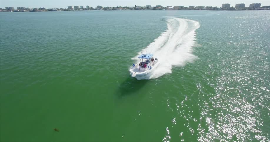 A boat is moving fast over green water