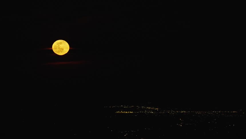 Aerial shot of a huge supermoon rising over an urban city as shot from the air, a passenger in a jetliner would see the same view on their cross country flight at night