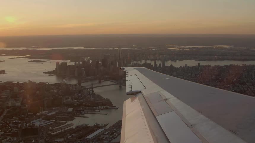View of a large city as seen from a passenger of a plane looking out over the wing
