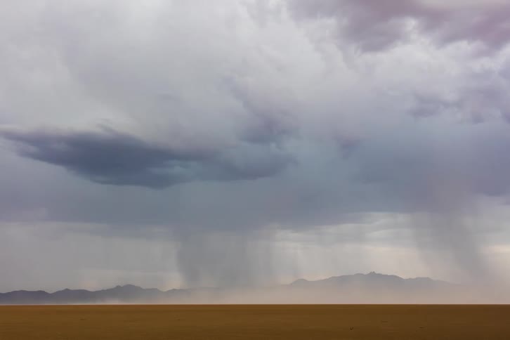 Lightning strikes as a storm moves over a desert