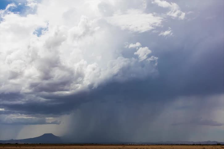 Skies turn dark as a storm moves over a desert