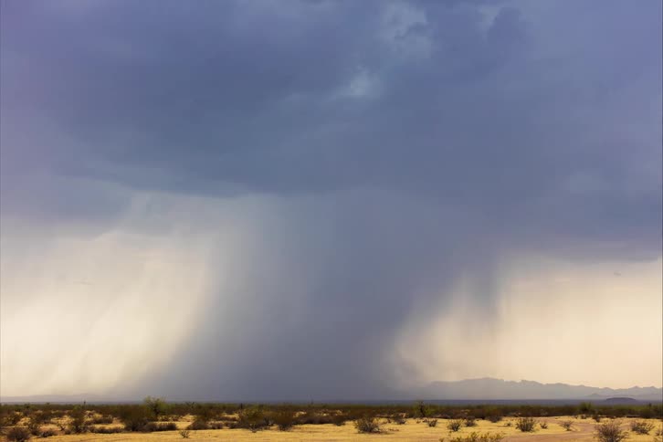 A view of a storm rolling over a field