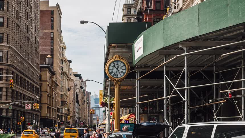 A time lapse of a city street shows countless cars and people passing by