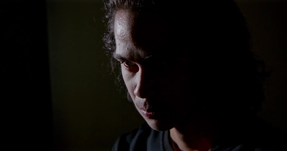 A man in a room with a wall in the background