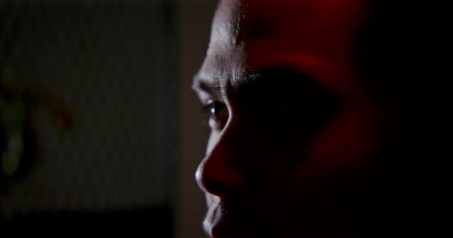 A close up image of a man sitting in a room