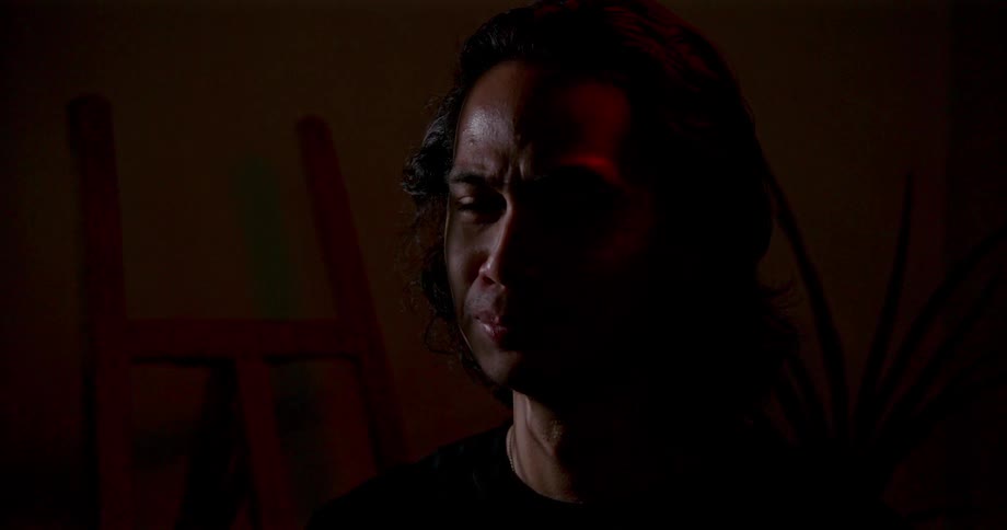 A portrait of a man sitting in a room crying