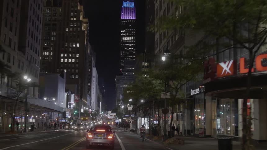 Traffic moving down a busy city street at night