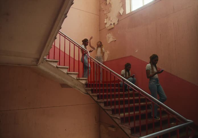 A woman using a smartphone walking down stairs