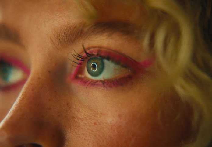 A woman face with makeup with light reflecting in her eyes